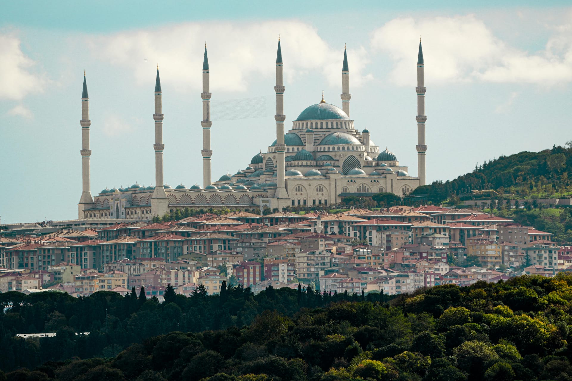 The massive Çamlıca Mosque with its six minarets sitting atop a green hill overlooking the city of Istanbul.